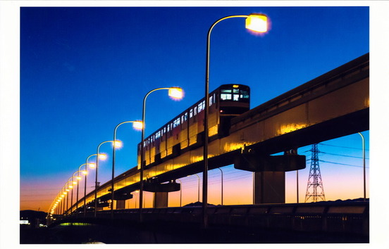 夕暮れに立日橋を走るモノレールの写真
