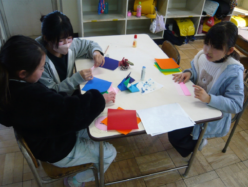 実習生が子どもと折り紙をしている
